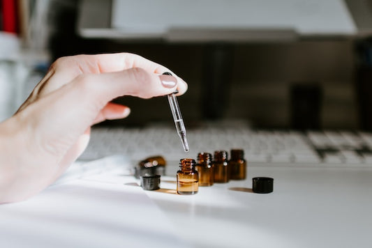 Cozy interior of a modern New Zealand home featuring a variety of elegant oil diffusers arranged on a wooden shelf, with soft light filtering through a window and a serene landscape visible in the bac