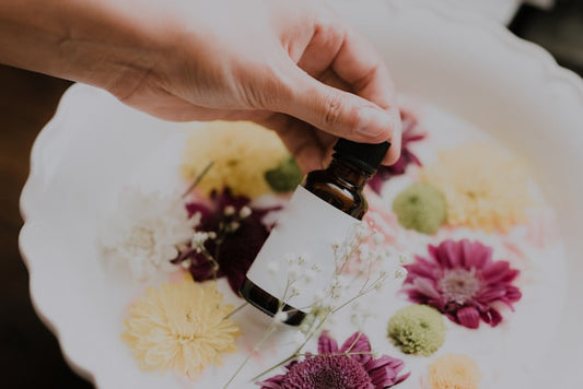 An elegant display of small glass bottles containing a variety of colorful essential oils, each labeled with natural ingredients like lavender, peppermint, and eucalyptus, set on a wooden table surrou